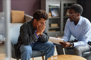a young man opens up to a counselor as part of his treatment plan for mental health services 