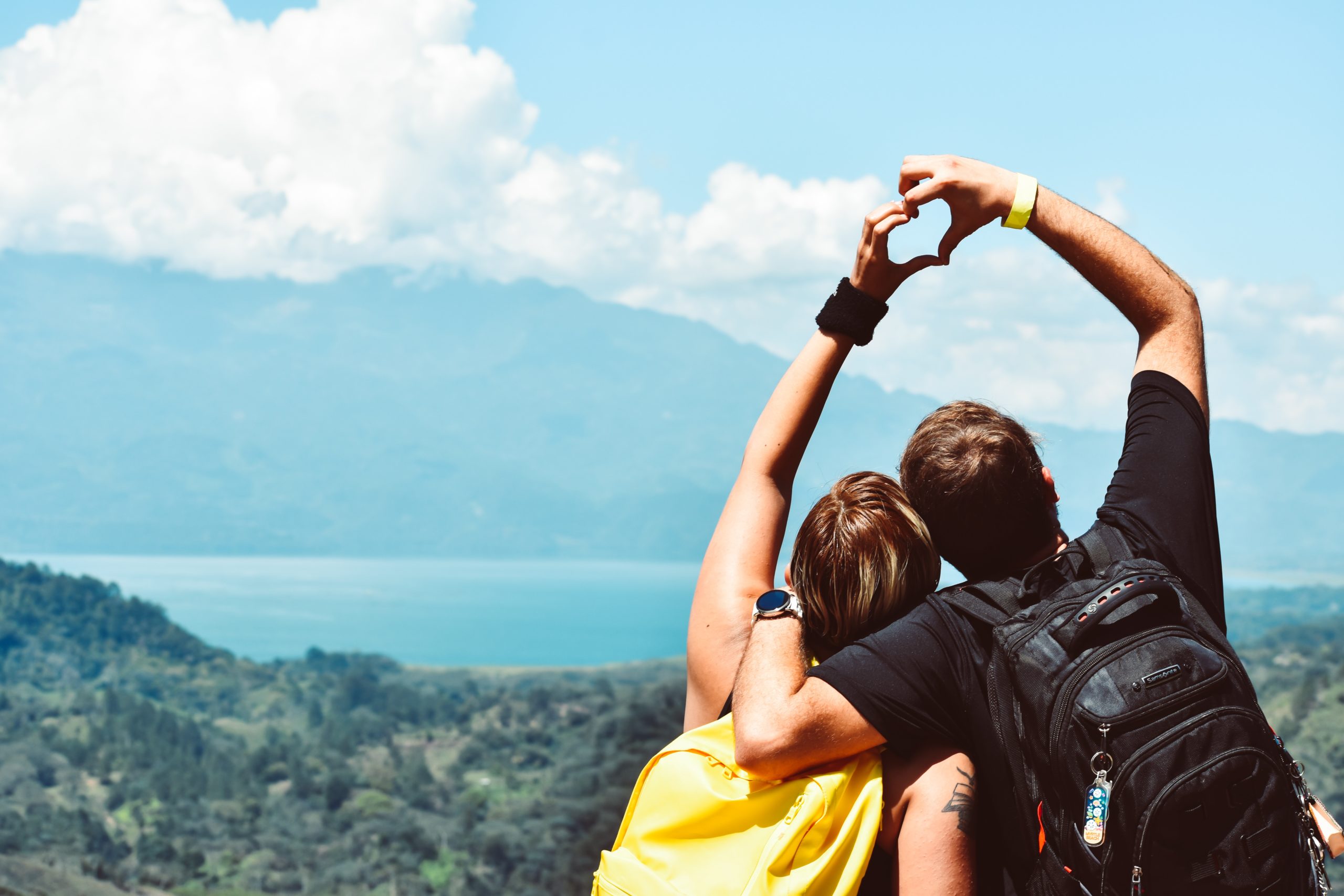 Couple making a heart with their hands on a mountain