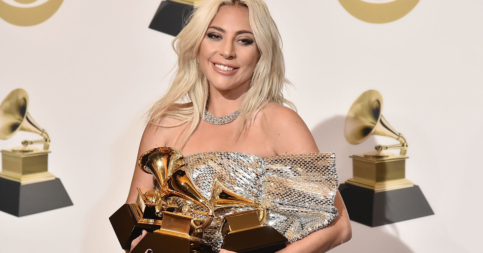 Lady Gaga holding her three Grammy awards