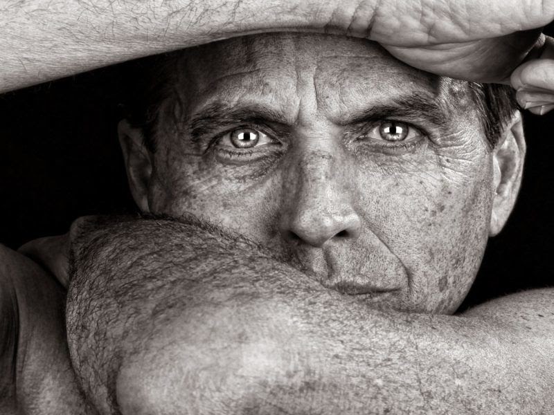 A black and white photo of a man staring into the camera.