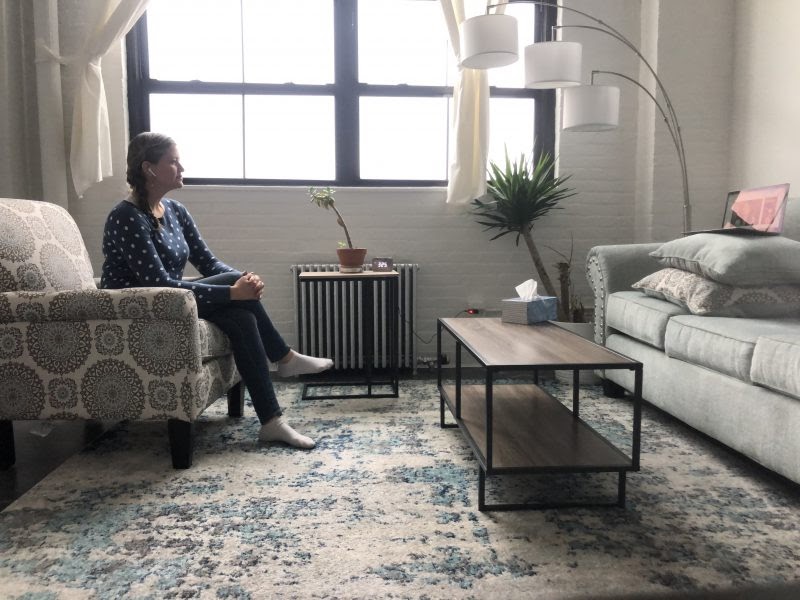 A woman sits alone in a therapist's office 