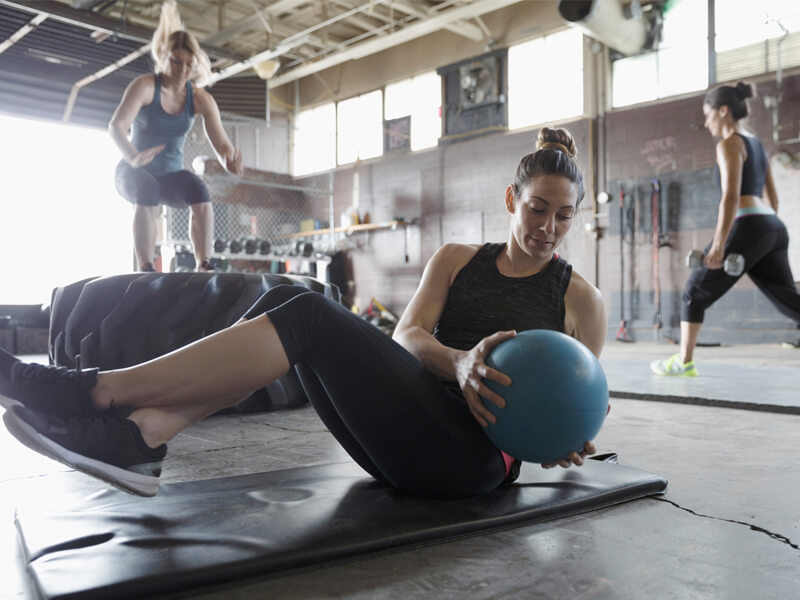 A woman does Russian twists with any exercise ball. 