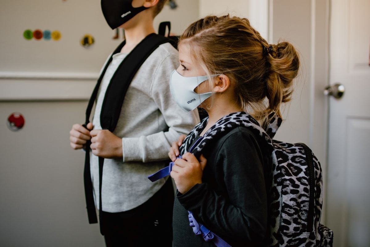 A pair of kids at school wearing masks