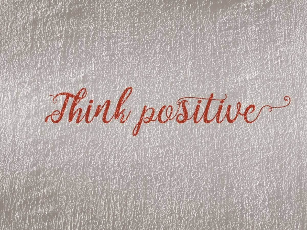 Text "Think Positive" Written in Cursive on Paper