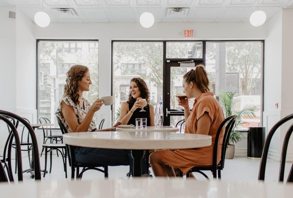 Three Women Sitting Around a Table, Relaxing