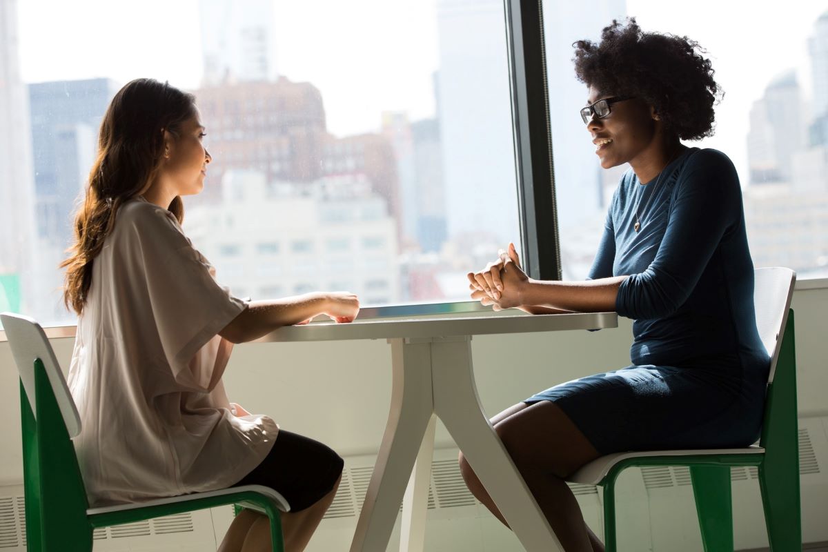 Two Women Conversing, Sitting at a Table