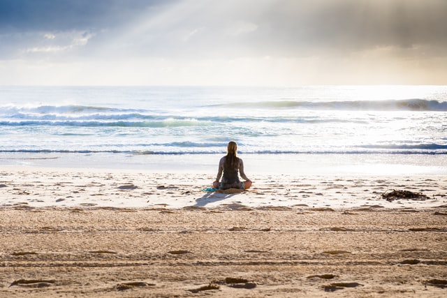 A Woman Meditating on a Beach