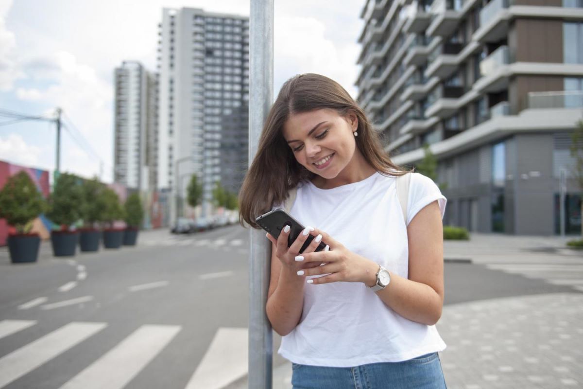 Woman Checking Phone in a City Intersection